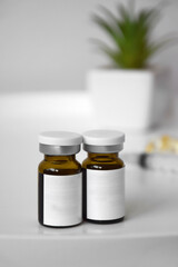 Cosmetic bottle for injection on the background of a syringe and a green flower.