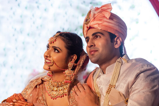 Side view of Indian bride and groom in traditional wedding outfit