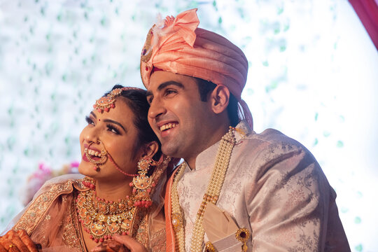 Side view of Indian bride and groom in traditional wedding outfit