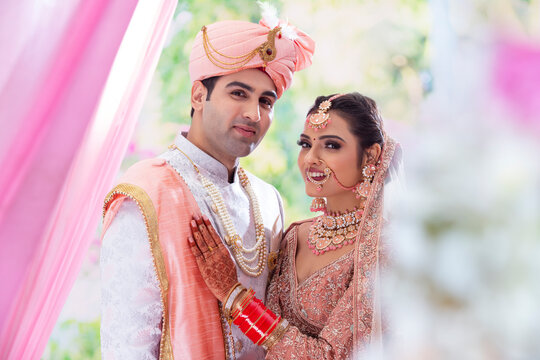 Portrait of an Indian wedding couple posing in front of camera for  photo album