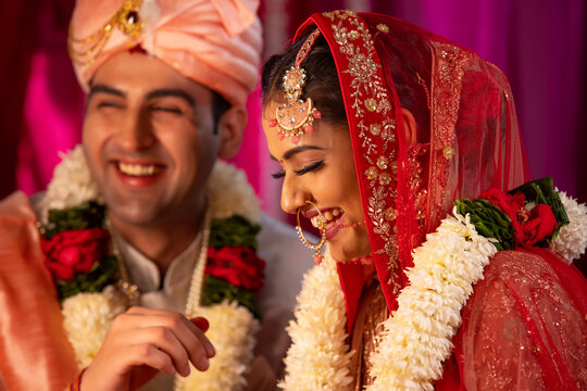 Indian groom putting sindoor on brides forehead during wedding ceremony