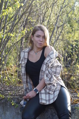 Smiling girl with light brown hair and a checkered shirt, sunny warm day.