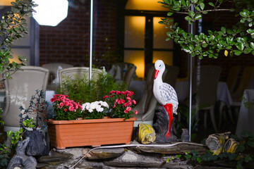 Birds sitting among flowers drink yellow-billed stork or Mycteria ibis and great heron or Bubulcus...
