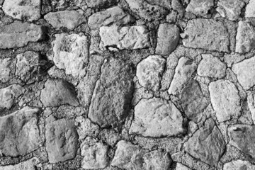 Black and white panorama stone wall for background design. Vintage of stone backdrop. Natural stone wall textured backdrop for a post, screensaver, wallpaper, postcard, poster, banner, cover