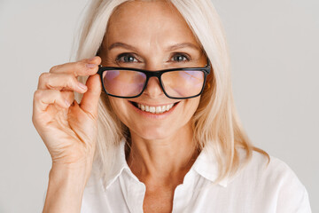 Mature woman in eyeglasses smiling and looking at camera