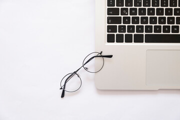 laptop and glasses on white minimalist background
