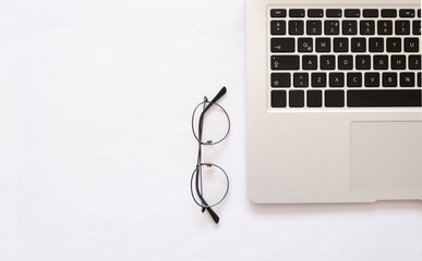 laptop and glasses on white minimalist background
