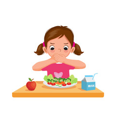 Cute picky eater little girl unhappy covering her mouth refusing to eat vegetables. - obrazy, fototapety, plakaty