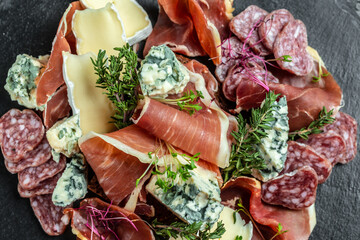 Antipasto with traditional Spanish meat snacks on a slate board, Antipasto platter. catering,...