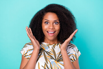 Photo of charming impressed dark skin woman dressed print blouse smiling rising arms isolated teal...