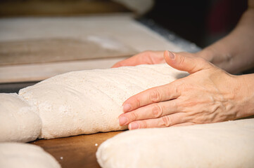 Close-up. Baker making bread, female hands, kneading dough, cooking. Caring for health and love while making healthy bread