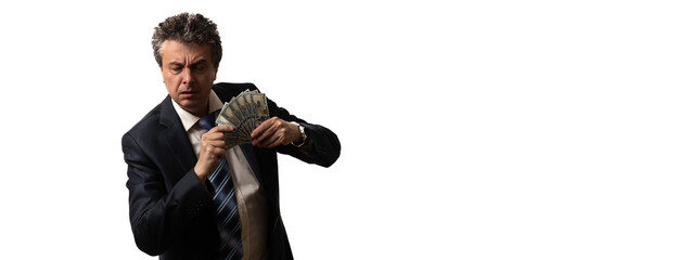 An unshaven middle-aged man in a business suit with disheveled hair and an emotional face holds 100 US dollar bills on a white background