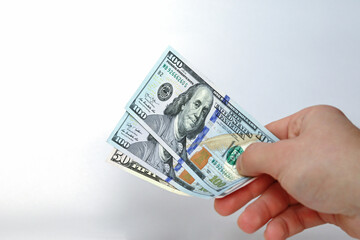 A man holds out hundred-dollar bills on a white background