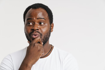 Black bristle man expressing surprise while holding his chin