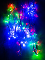 multicolored garland with small led bulbs on a dark background