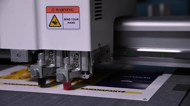 Close-up shallow depth of field a production plotter at a printing house automatically cuts packaging and labels from cardboard