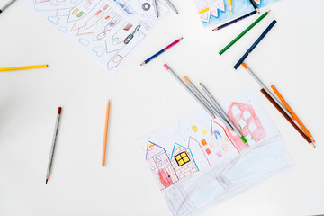 Photo of drawings and colored pencils at art school indoors