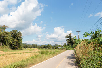 white clouds in blue sky and country road