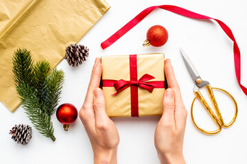 Golden gift box in female hands. Present for Christmas