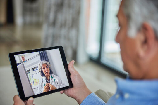 Man Having Remote Consultation With Doctor At Home Using Digital Tablet
