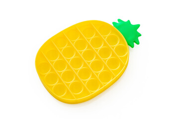 Yellow silicone sensory pineapple toy simple dimple, pop it on white background