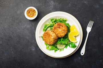 Cod fish potato cakes served with lemon and honey mustard. Top view.