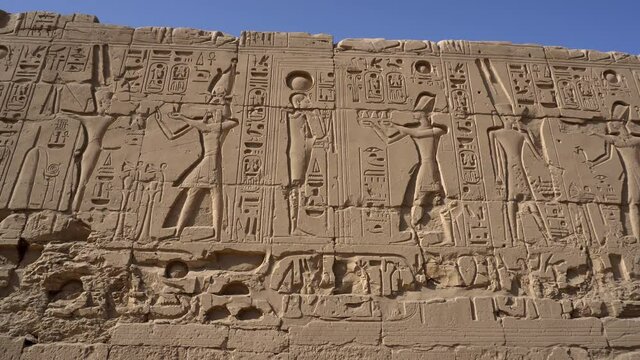Karnak temple large size hieroglyphic wall with gods and pharaoh