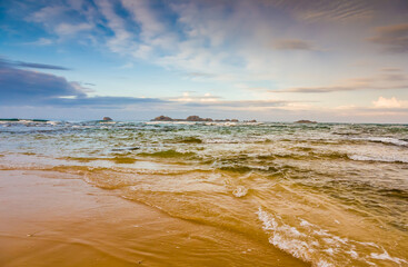 Landscape with a sandy seashore against the sky with clouds in the city of Hikkaduwa in Sri Lanka