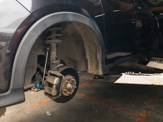 Lift is lifting a black car, removing the wheels, a car suspension repair concept. tire change