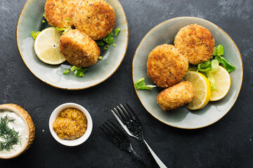 Fish cod potato cakes. Fish fritters with sauces and lemon wedges. Top view