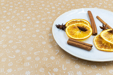 Cinnamon sticks, star-anise and dried orange slices on a plate
