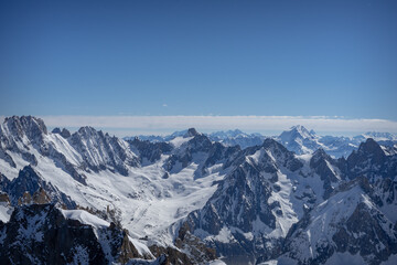Fototapeta na wymiar A view of the French Alps, Swiss Alps, and Italian Alps on a sunny summer day from the Aiguille du Midi near Mont Blanc in Chamonix, France