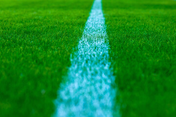 Football field with artificial green grass. Amateur football field. Sunny summer day.