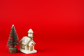 christmas card. Christmas tree and cute cottage on a red background.