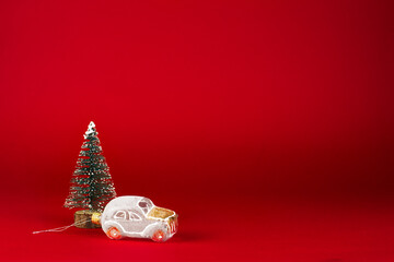 christmas card. White retro car next to a snow-covered Christmas tree on a red background.