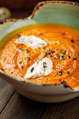 Gourmet lentil cream soup with herbs on wooden background