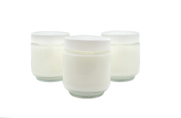 Obraz na płótnie Canvas Three glass jars of yogurt or cream isolated on a white background. Yogurt, milk or dessert. 