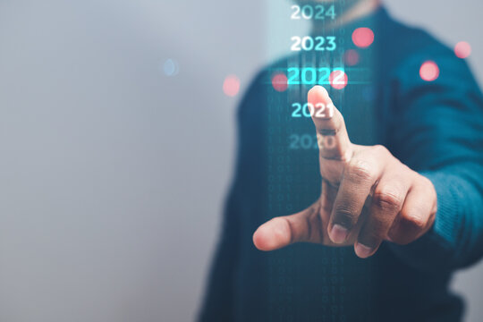 Business man pointing at digital calendar countdown to new year. 2022 concept. Space for text. - Powered by Adobe
