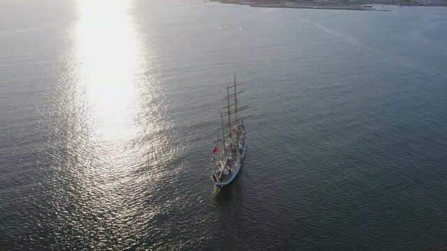 Mediterranean Sea with sailboat at sunset. Top view of the Atlantic Ocean. Coast of Spain. Sailing vessel aerial drone view.