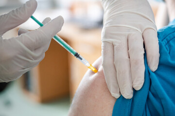 A patient getting a covid19 vaccine injection / A close-up picture of a doctor giving a covid-19 vaccination injection.