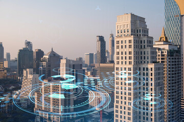Glowing hologram of technological process, aerial panoramic cityscape of Bangkok at sunset. The...