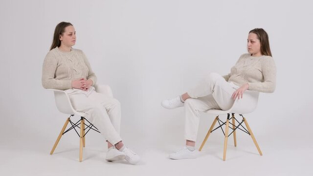 Woman talking with her clone on white background