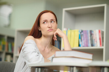 Sad woman in library looking to side