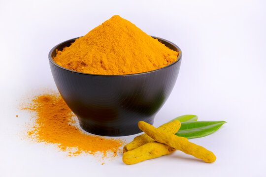 Turmeric Powder, Tumeric rhizome and turmeric powder in bowl isolated on white background, indian spice, healthy seasoning ingredient for vegan cuisine.