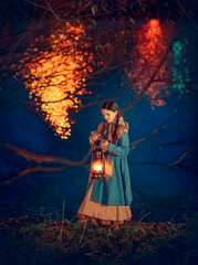 Girl with lantern near lake in the night autumn park