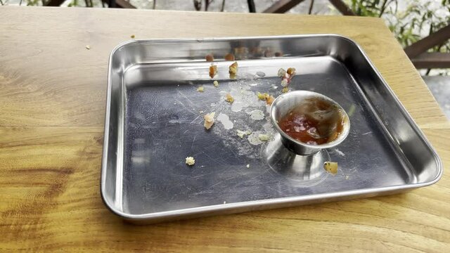 Empty metal tray with remains of burger ketchup