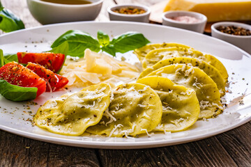 Medaglioni with cheese, basil and pine nuts on wooden table
