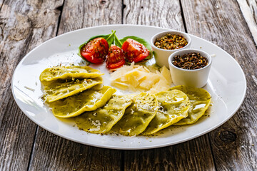 Medaglioni with cheese, basil and pine nuts on wooden table
