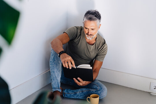 Old male in corner enjoying book reading