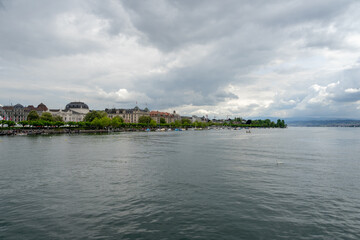 Fototapeta na wymiar The Limmat River flows into Lake Zurich (Zurichsee) on a cloudy spring afternoon in Zurich, Switzerland